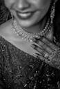 Close-up black and white portrait featuring intricate jewelry and henna designs.
